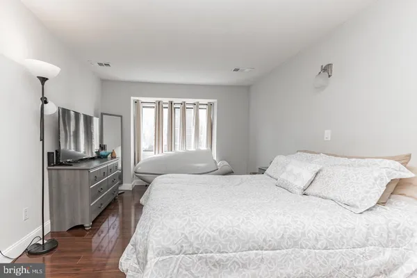 a bedroom with a bed cabinets and wooden floor