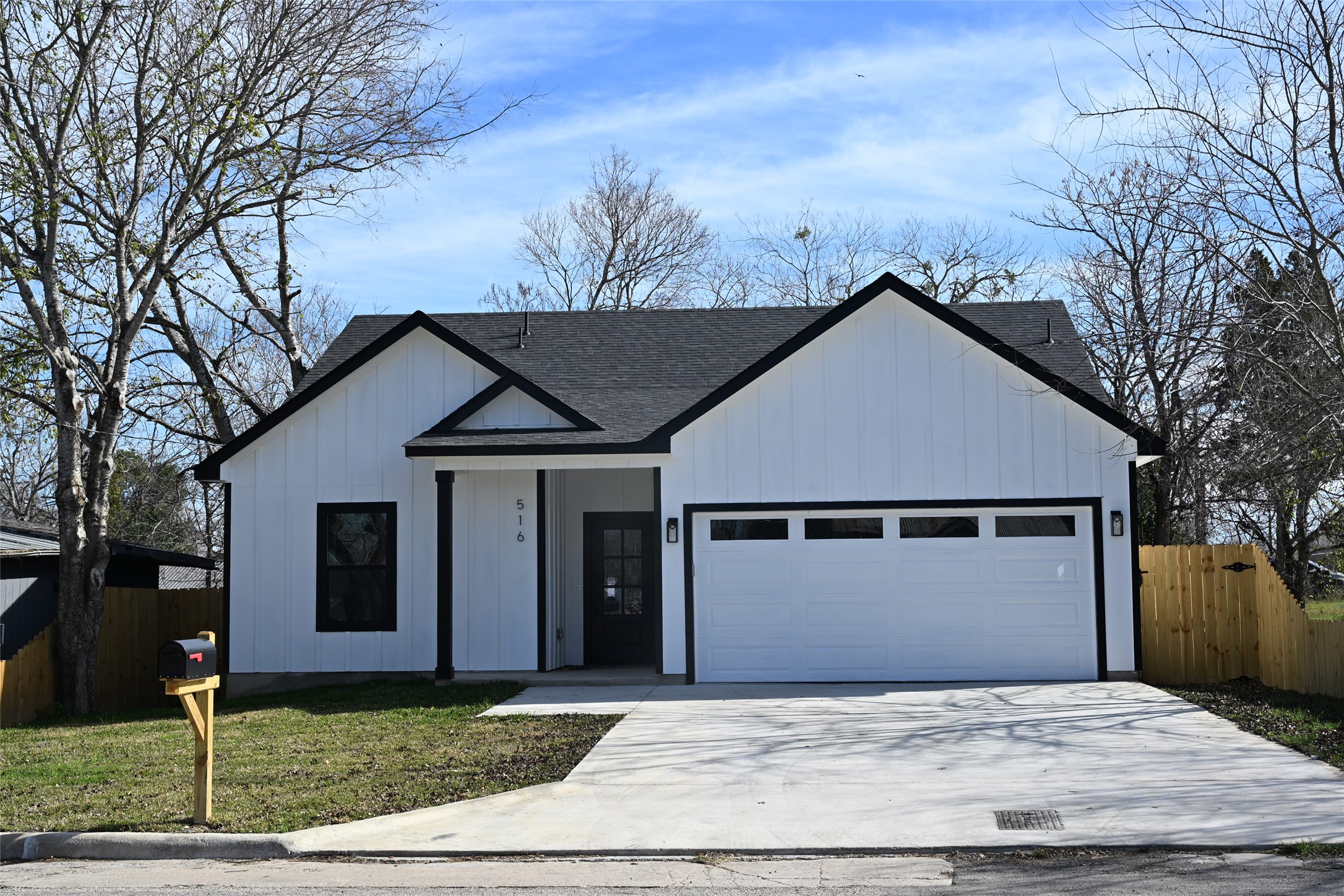 516 North Hackberry Avenue Luling, TX 78648 - Photo 1 of 36 Modern farmhouse style home with concrete driveway, roof with shingles, board and batten siding, a garage, and a porch