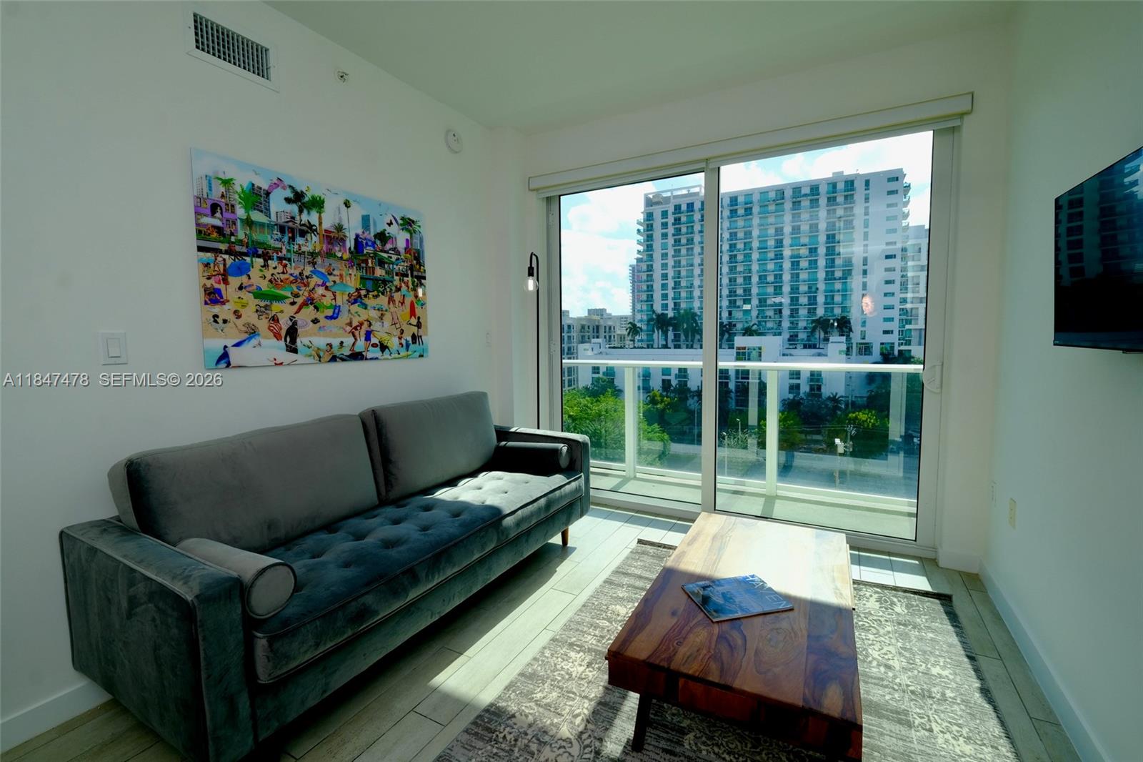 321 Northeast 26th Street, Unit 709 Miami, FL 33137 - Photo 3 of 13 a living room with furniture and a floor to ceiling window
