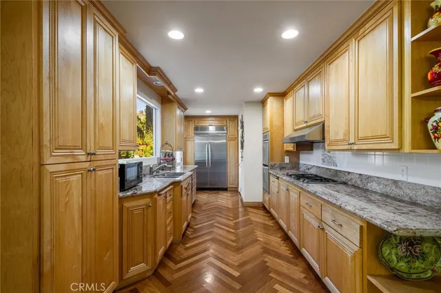 a kitchen with granite countertop a sink and a refrigerator