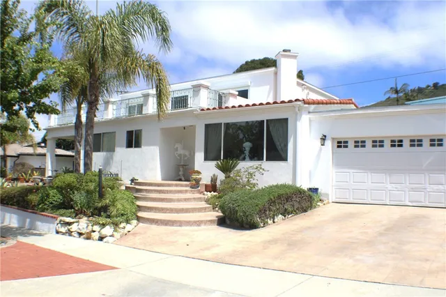 a front view of a house with a yard and potted plants