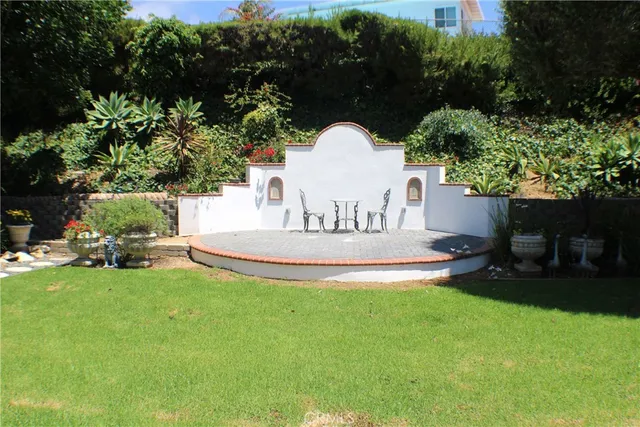 a front view of a house with a yard and potted plants