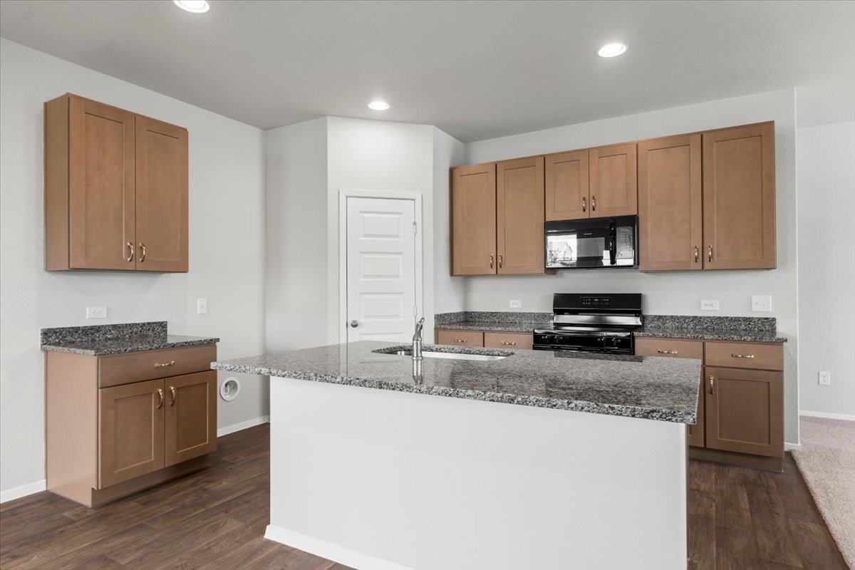 13300 Riding Drive Manor, TX 78653 - Photo 10 of 38 Kitchen with black appliances, a sink, dark wood-style floors, dark stone counters, and recessed lighting