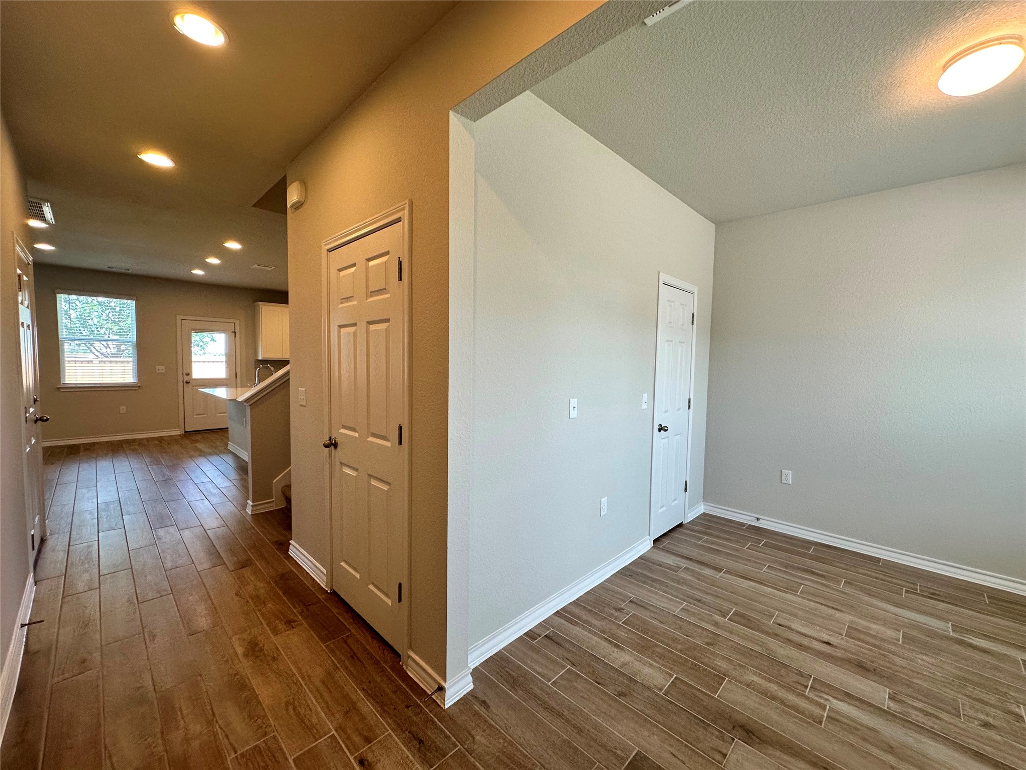 1624 Caballo Blanco Road Austin, TX 78725 - Photo 2 of 23 Rich wood-look tile flooring extends throughout this versatile living space.