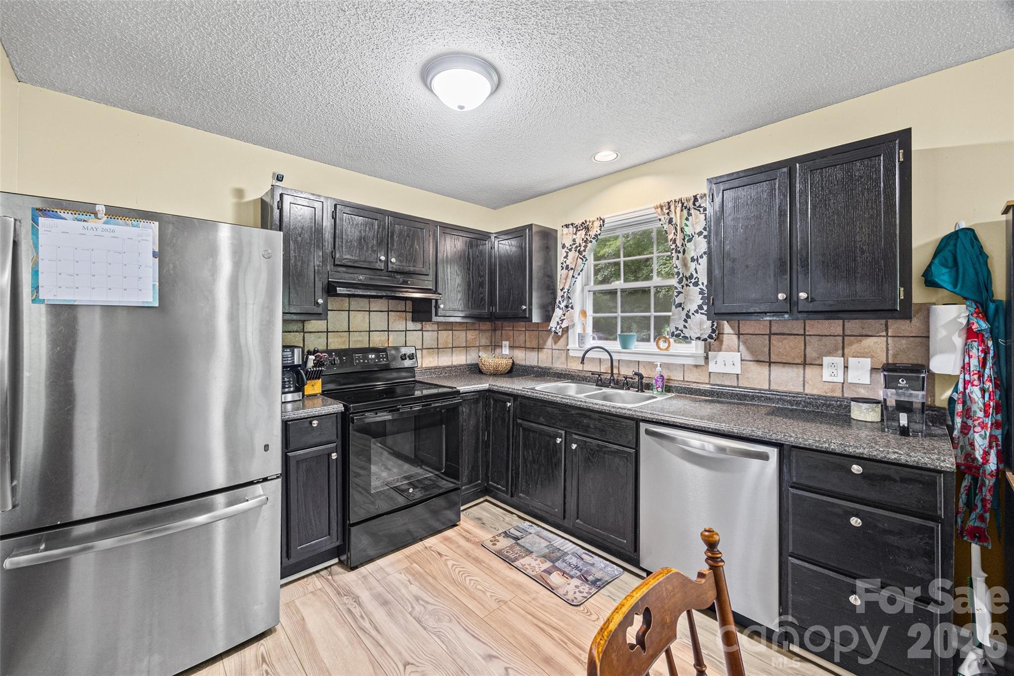 30 7th Street York, SC 29745 - Photo 7 of 29 a kitchen with stainless steel appliances granite countertop a refrigerator sink and wooden cabinets