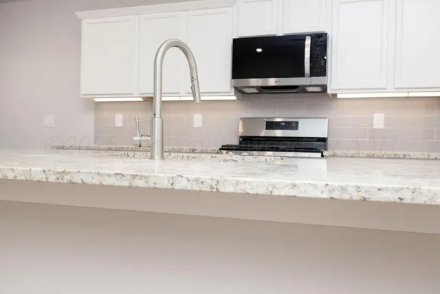 a kitchen with stainless steel appliances granite countertop a sink and a stove top oven