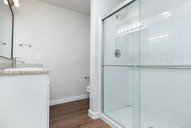 a bathroom with a glass shower door and a sink