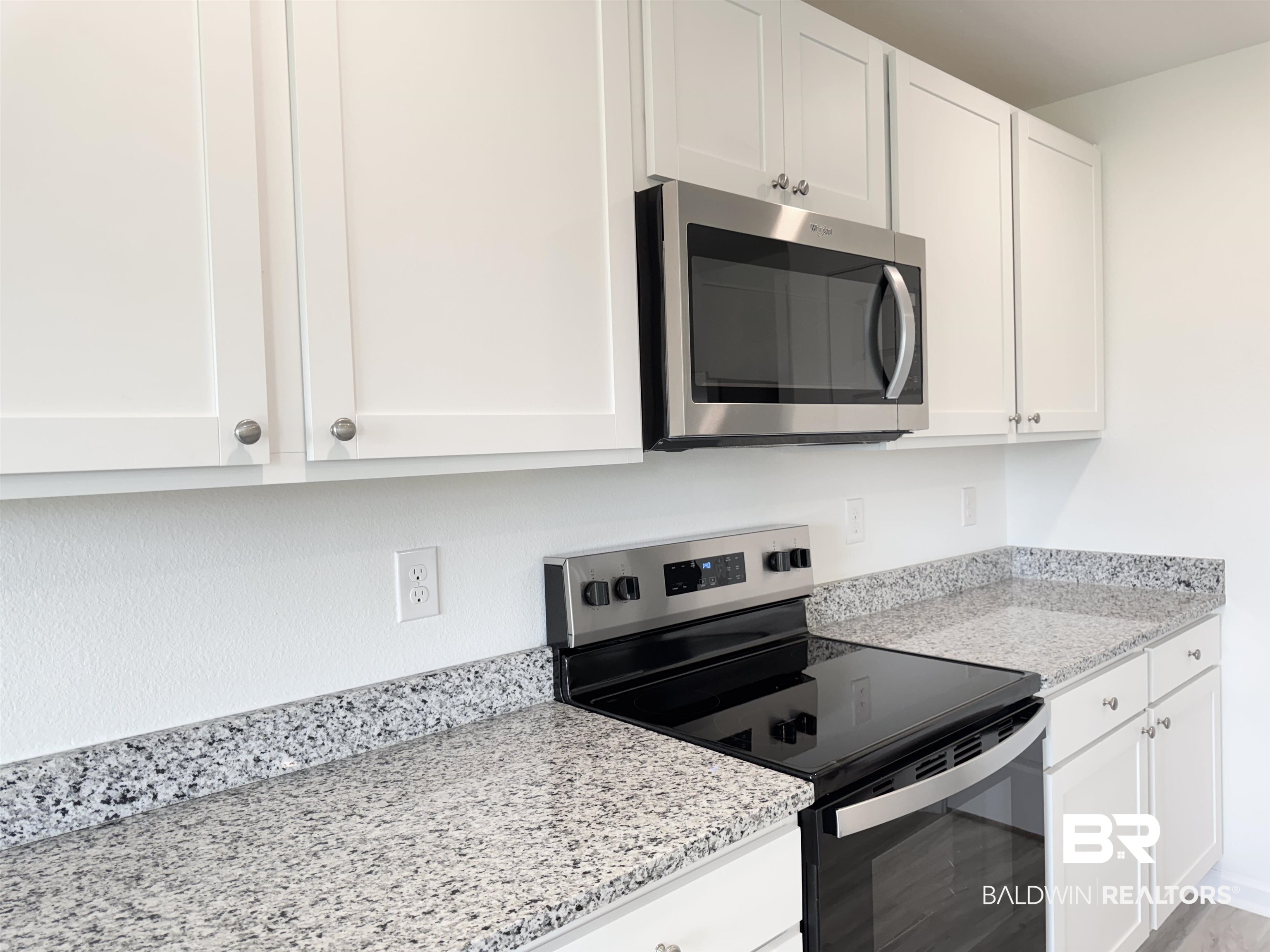 22072 Aleutian Avenue Foley, AL 36535 - Photo 33 of 47 Kitchen featuring stainless steel appliances, white cabinets, and light stone countertops