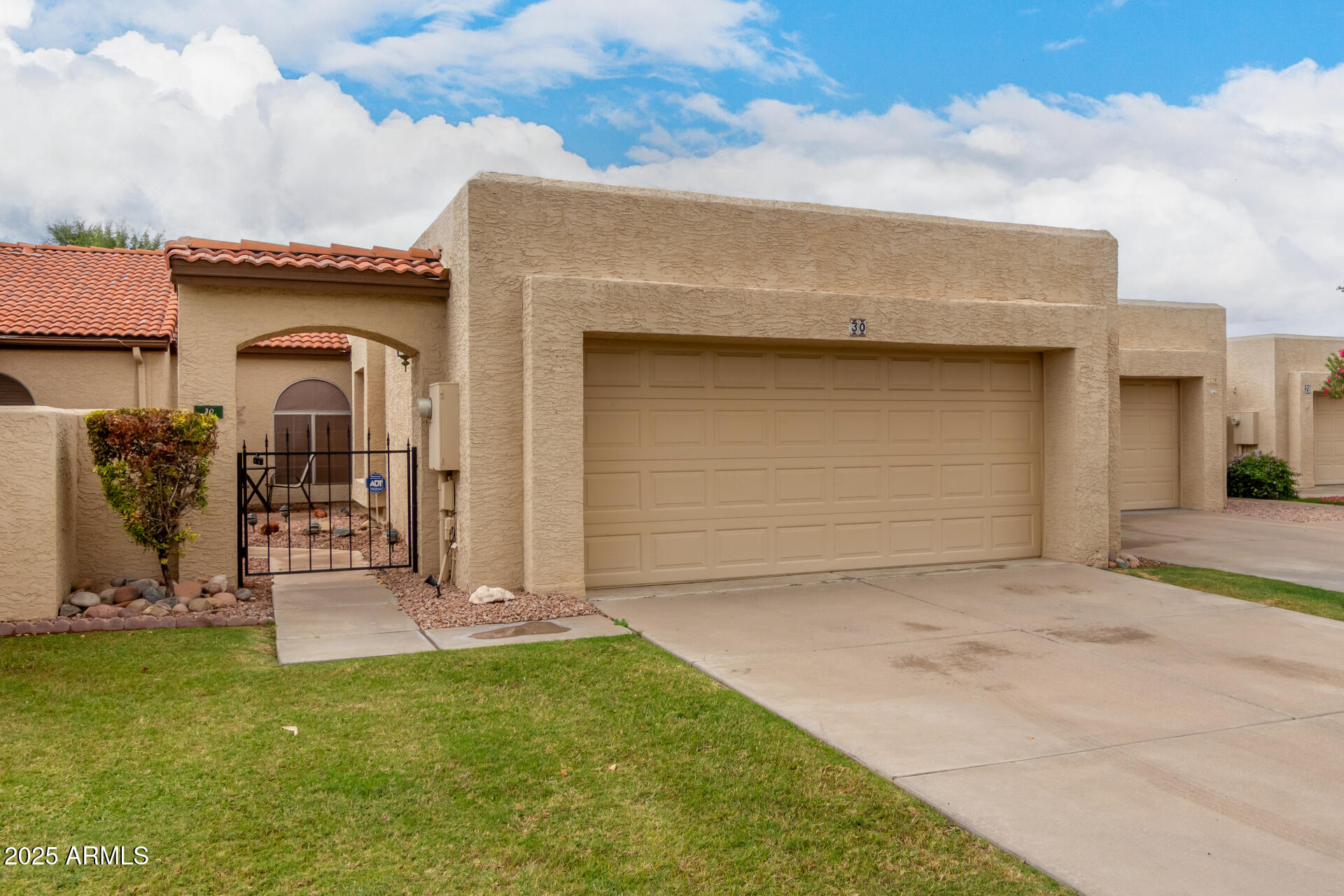2059 East Brown Road, Unit 30 Mesa, AZ 85213 - Photo 2 of 24 a front view of a house with a garden