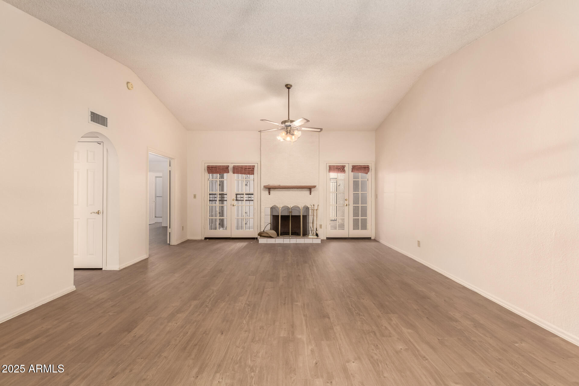 2059 East Brown Road, Unit 30 Mesa, AZ 85213 - Photo 5 of 24 an empty room with wooden floor fireplace and window