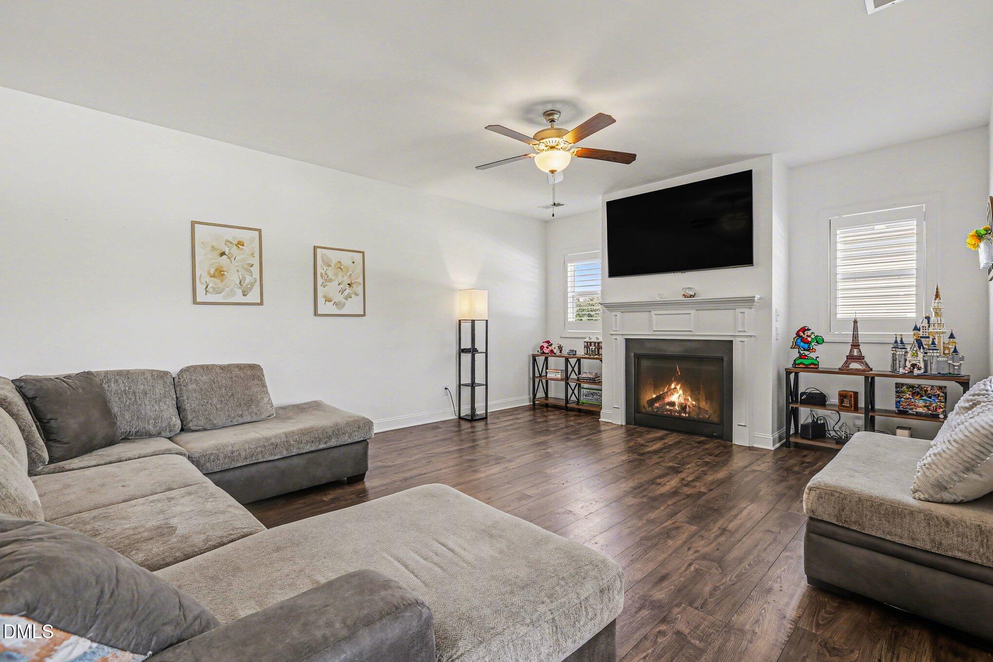 432 Seabring Lane Raleigh, NC 27603 - Photo 6 of 29 a living room with furniture a fireplace and a flat screen tv