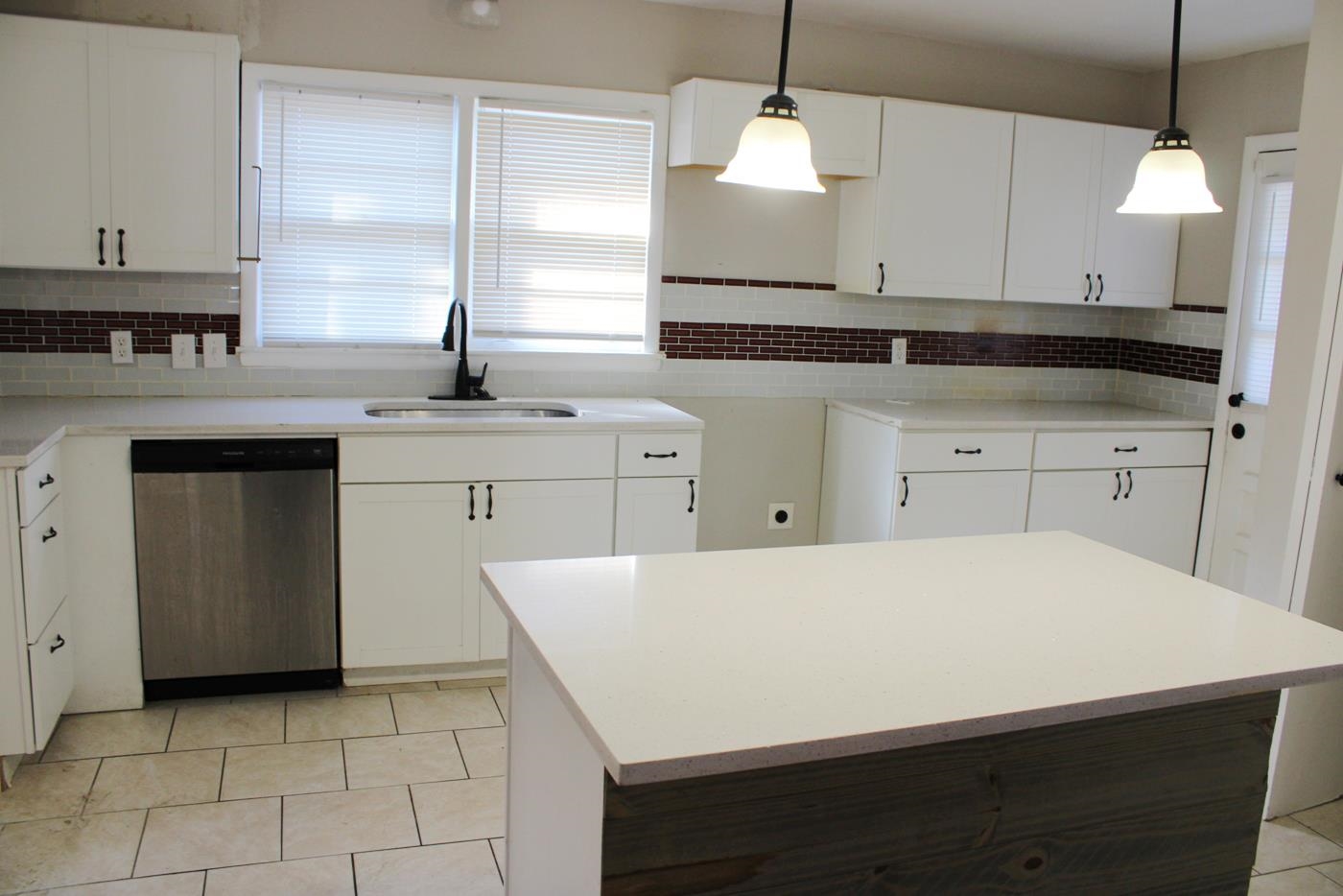 1673 South White Station Road Memphis, TN 38117 - Photo 13 of 17 Kitchen featuring stainless steel dishwasher, white cabinets, tasteful backsplash, and hanging light fixtures