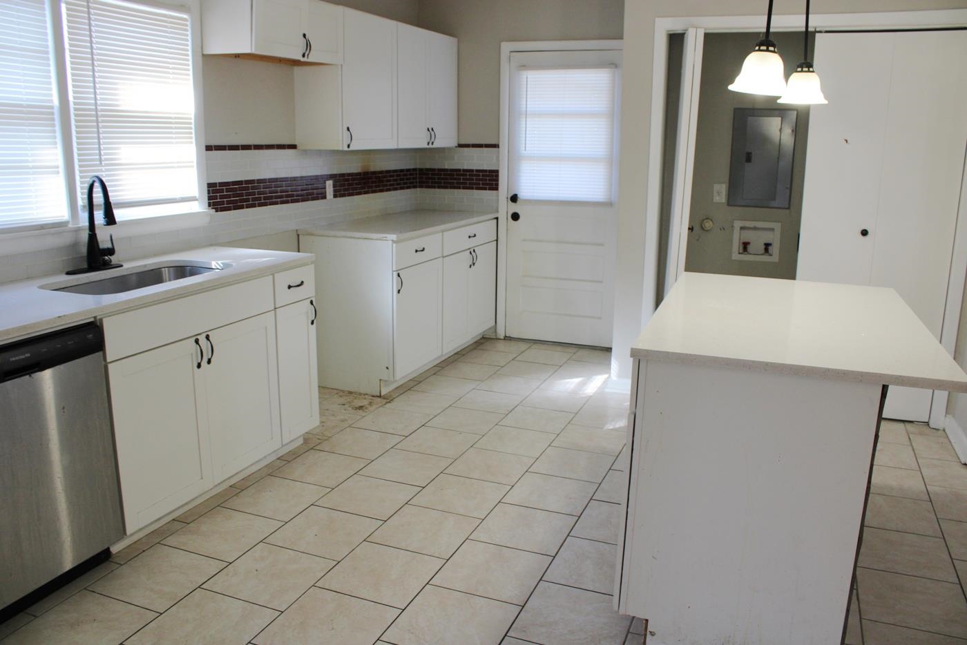1673 South White Station Road Memphis, TN 38117 - Photo 15 of 17 Kitchen with white cabinets, stainless steel dishwasher, electric panel, decorative light fixtures, and tasteful backsplash