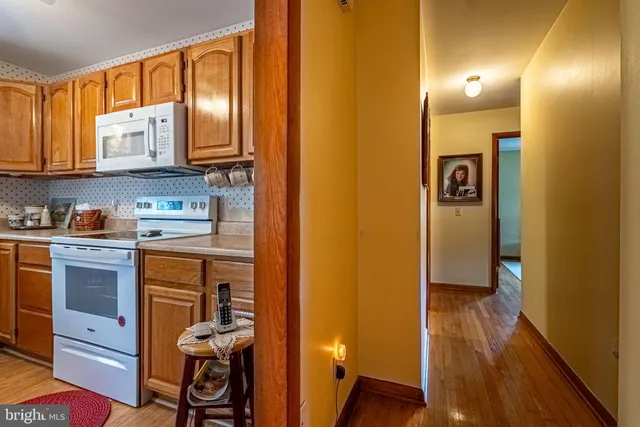a kitchen with stainless steel appliances granite countertop a refrigerator a stove and a sink with cabinets