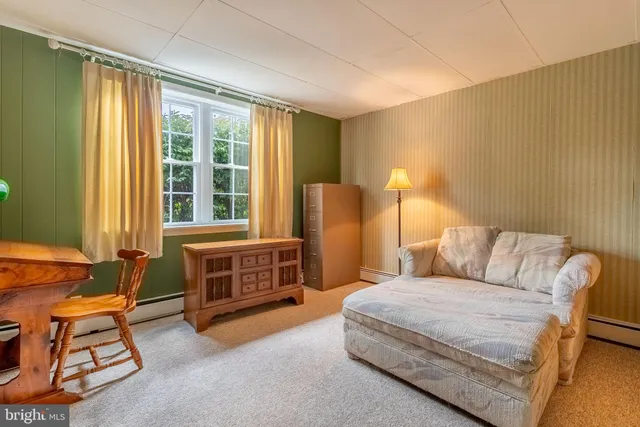 a bedroom with a bed and a dresser next to a window