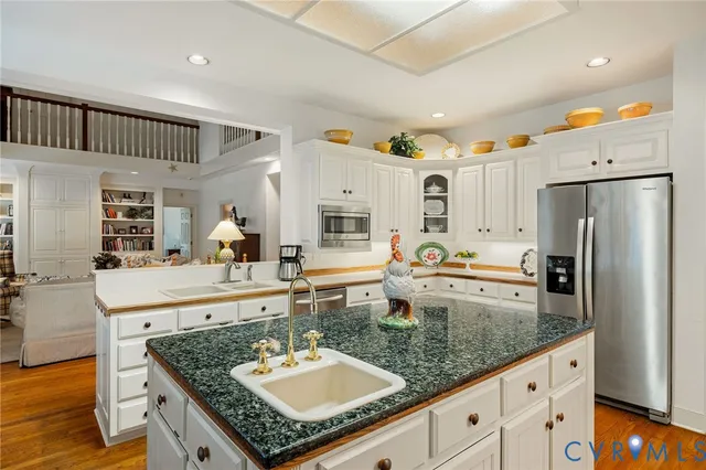a kitchen with stainless steel appliances granite countertop a sink refrigerator and cabinets