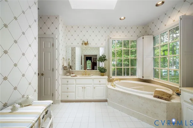 a spacious bathroom with a tub sink and mirror