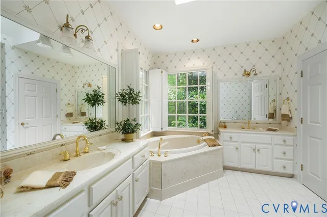 a bathroom with a granite countertop tub sink and mirror