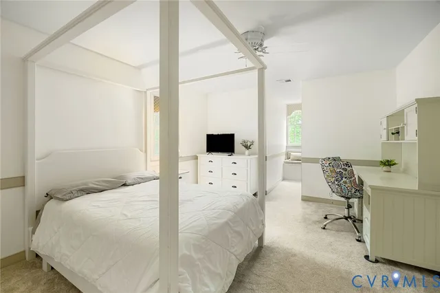 a bedroom with a bed large window and couch