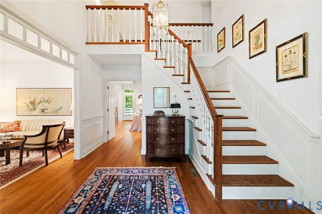 a view of a hallway with wooden floor and staircase