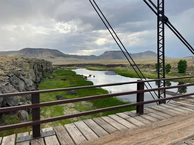 a view of a balcony with wooden floor next to a yard