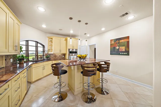 a kitchen with a dining table cabinets appliances and a window