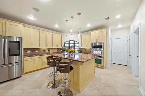 a kitchen with stainless steel appliances kitchen island granite countertop a stove top oven sink and cabinets