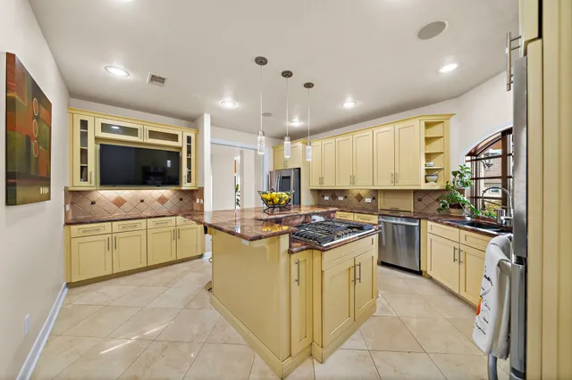 a kitchen with stainless steel appliances kitchen island granite countertop a stove top oven sink and cabinets