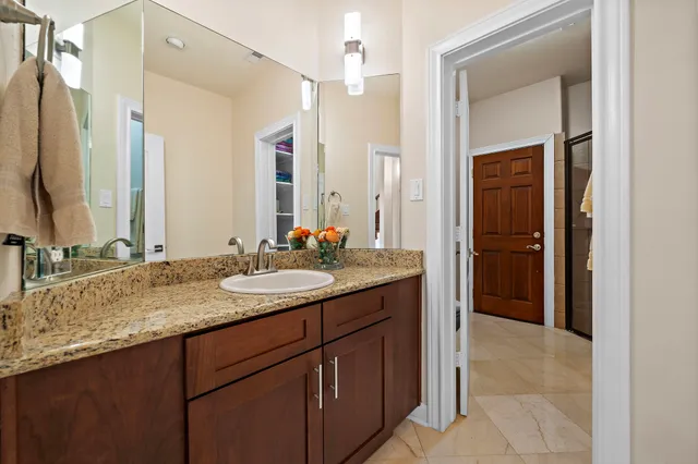 a bathroom with a granite countertop sink and a mirror