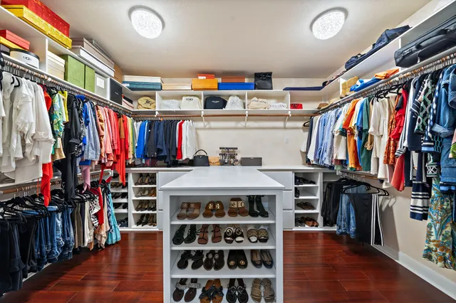 a view of walk in closet with clothes and shoes