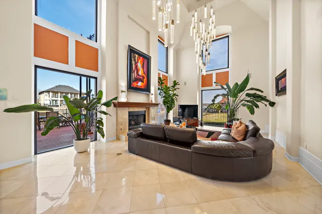 a living room with furniture a fireplace and a chandelier
