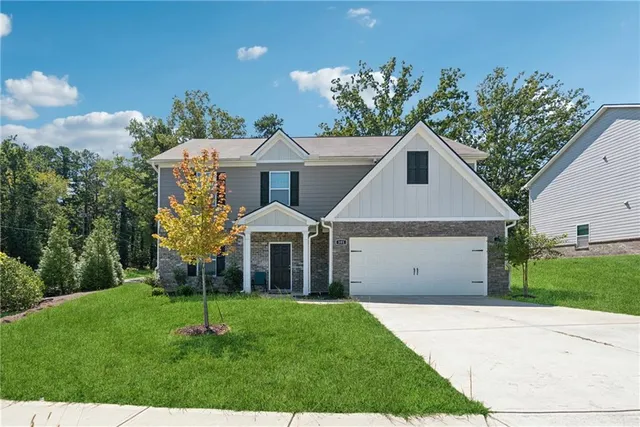 a front view of a house with a yard and potted plants