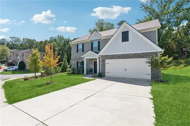 a front view of a house with a yard and trees