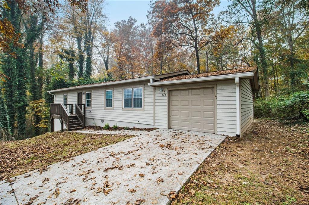 a backyard of a house with large trees and wooden fence