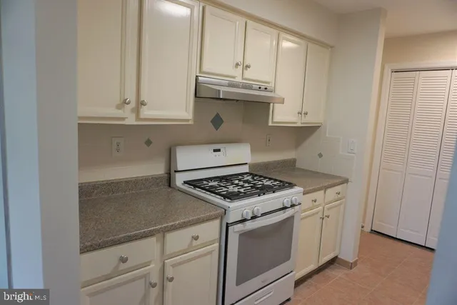a kitchen with white cabinets and appliances