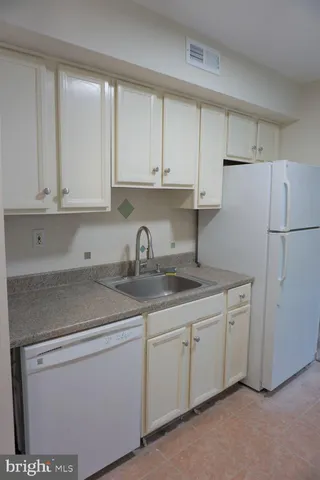 a kitchen with stainless steel appliances granite countertop white cabinets sink and dishwasher