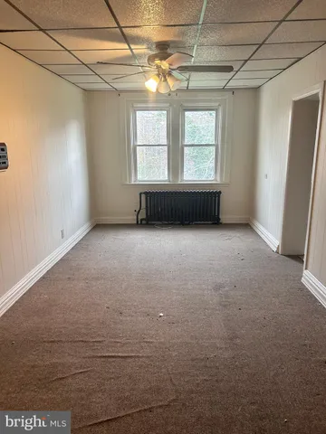 an empty room with windows and chandelier