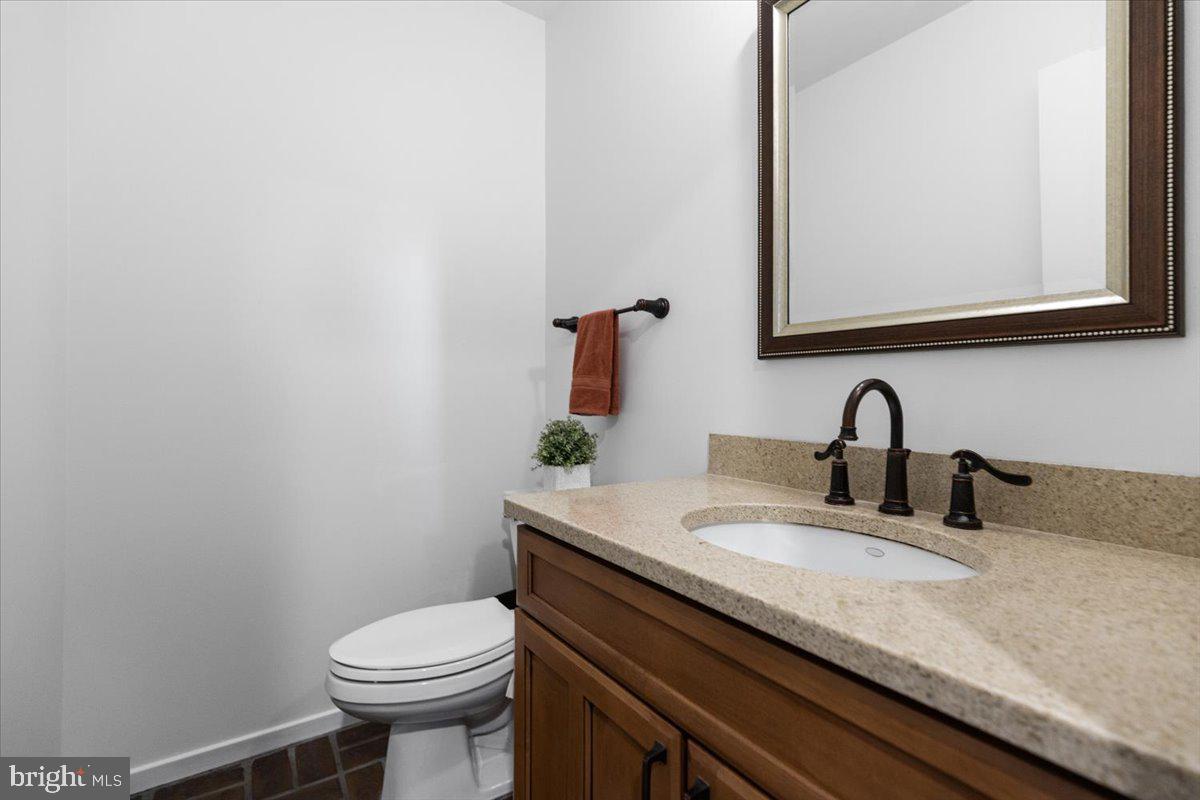 9411 Fernwood Road Bethesda, MD 20817 - Photo 29 of 101 a bathroom with a granite countertop sink and a toilet
