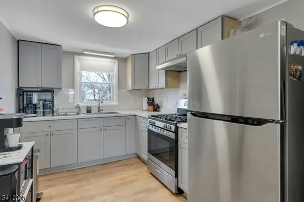 a kitchen with a refrigerator a sink and cabinets