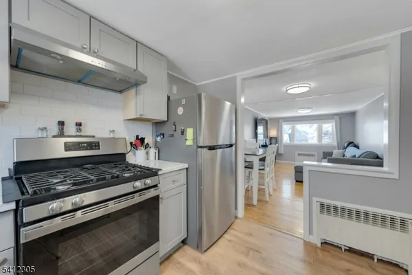 a kitchen with stainless steel appliances granite countertop a stove refrigerator and cabinets