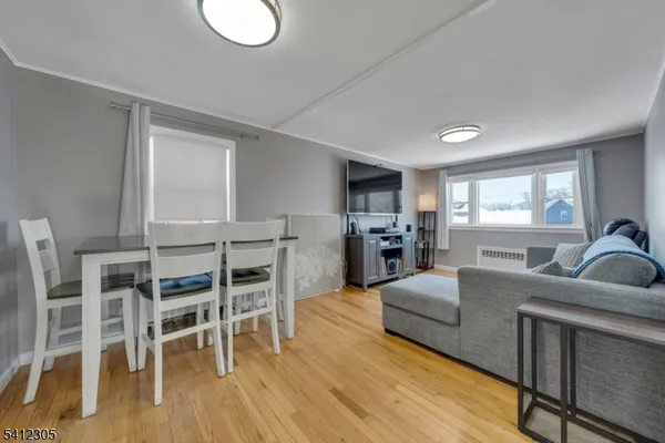 a living room with furniture a dining table and wooden floor