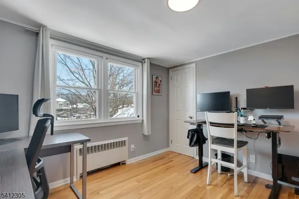 a view of a workspace with furniture and a window