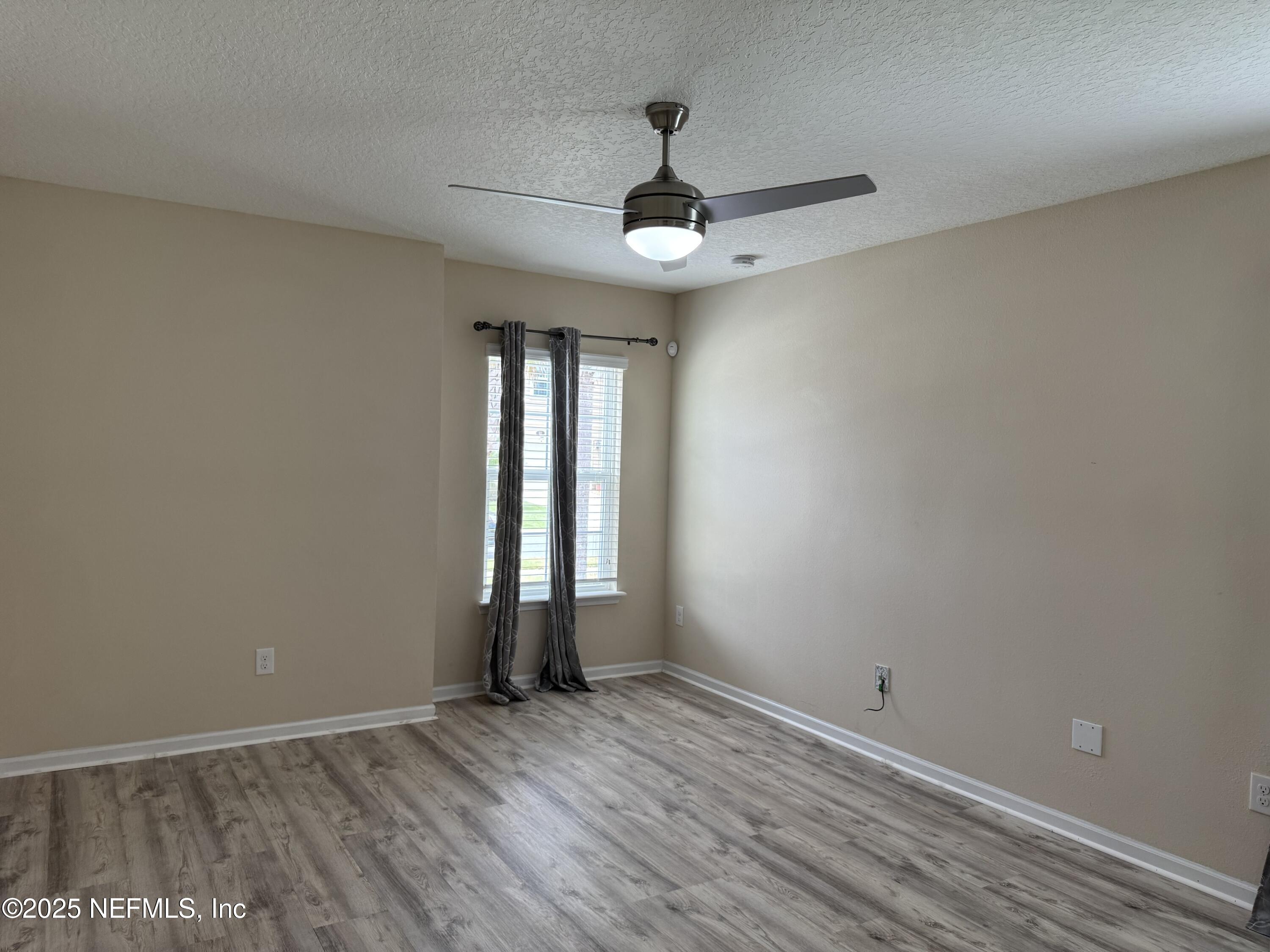 96 Midway Park Drive St. Augustine, FL 32084 - Photo 17 of 31 an empty room with wooden floor and windows