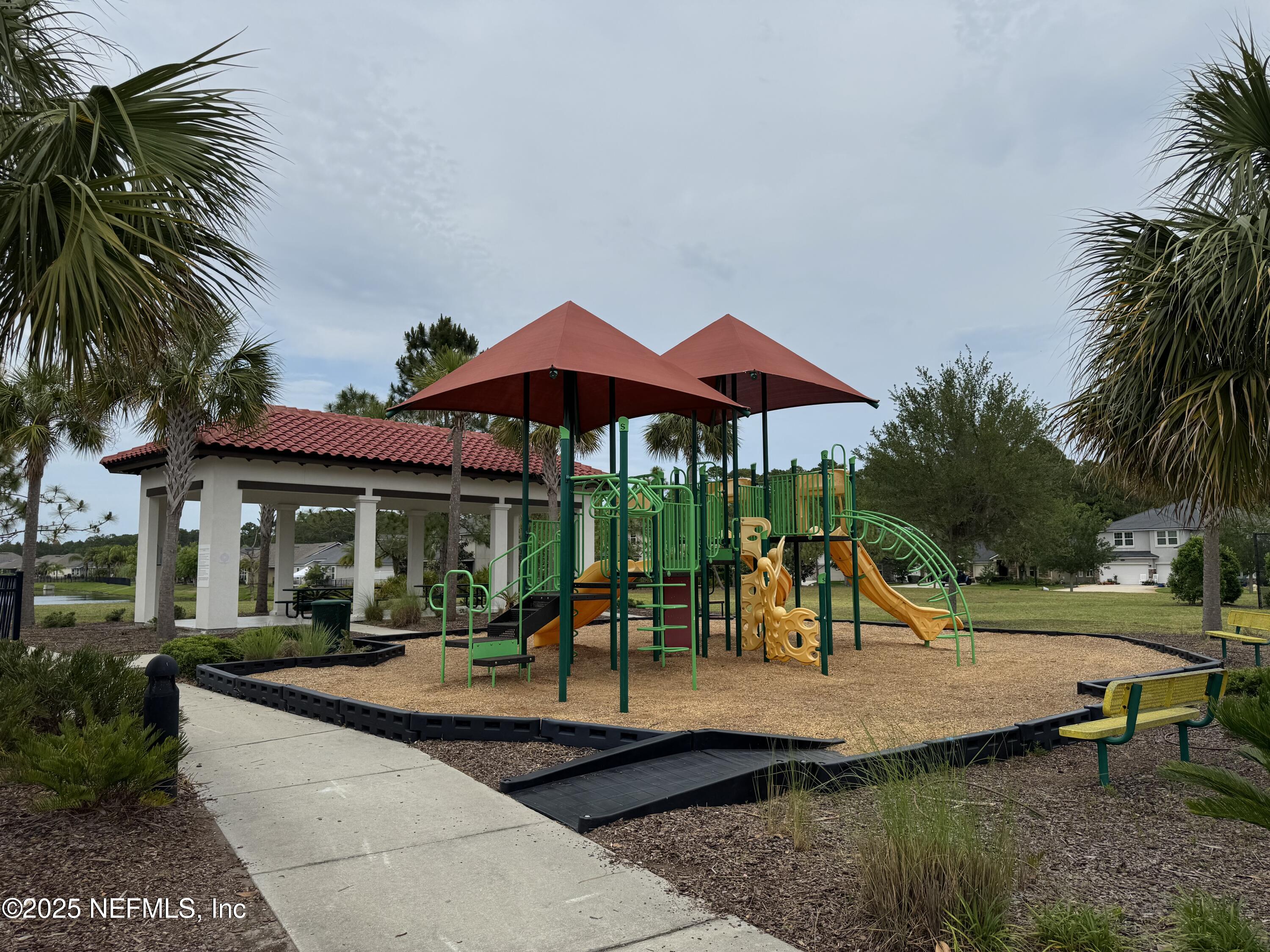 96 Midway Park Drive St. Augustine, FL 32084 - Photo 30 of 31 a view of a swimming pool with a table and chairs under an umbrella