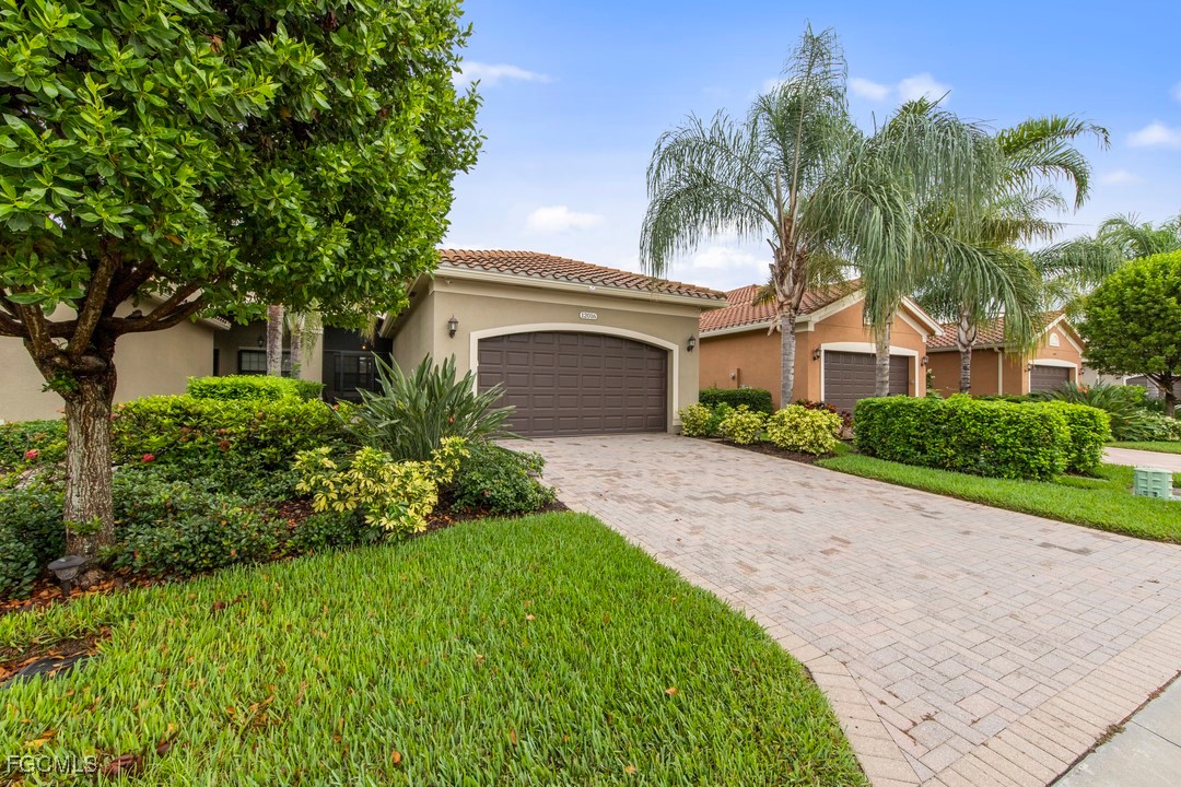 12016 Five Waters Circle Fort Myers, FL 33913 - Photo 11 of 19 a front view of a house with a garden