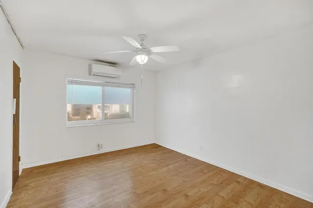an empty room with a ceiling fan and a window