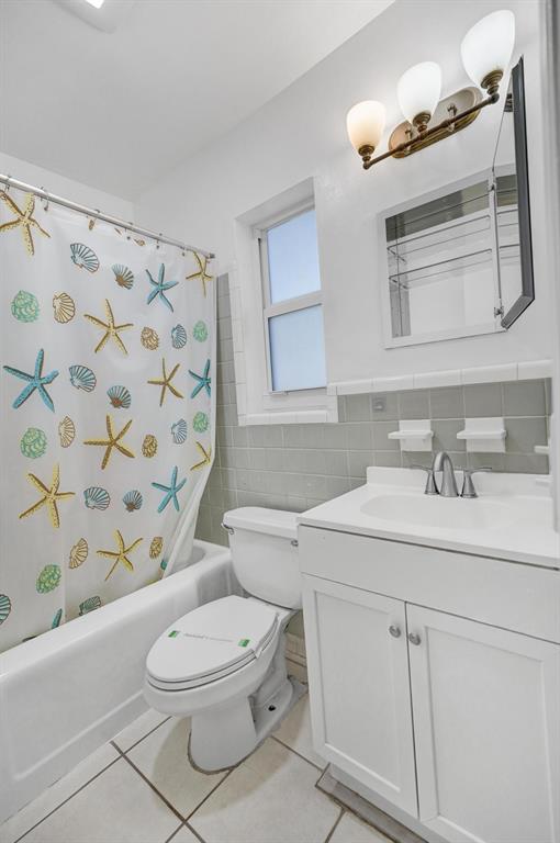 326 Madison Street, Unit 2 Hollywood, FL 33019 - Photo 21 of 27 a bathroom with a sink a toilet and shower curtain