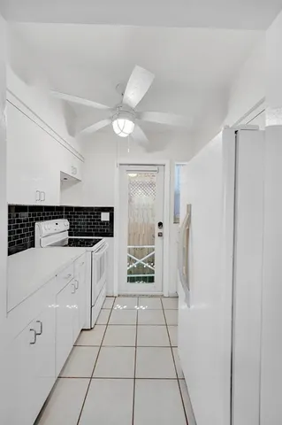 a kitchen with white cabinets and sink