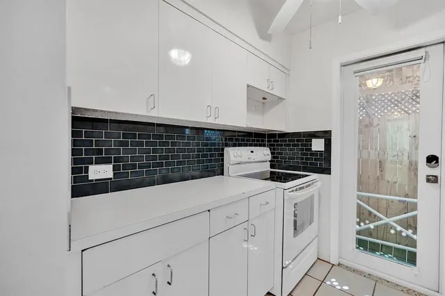 a kitchen with white cabinets and appliances