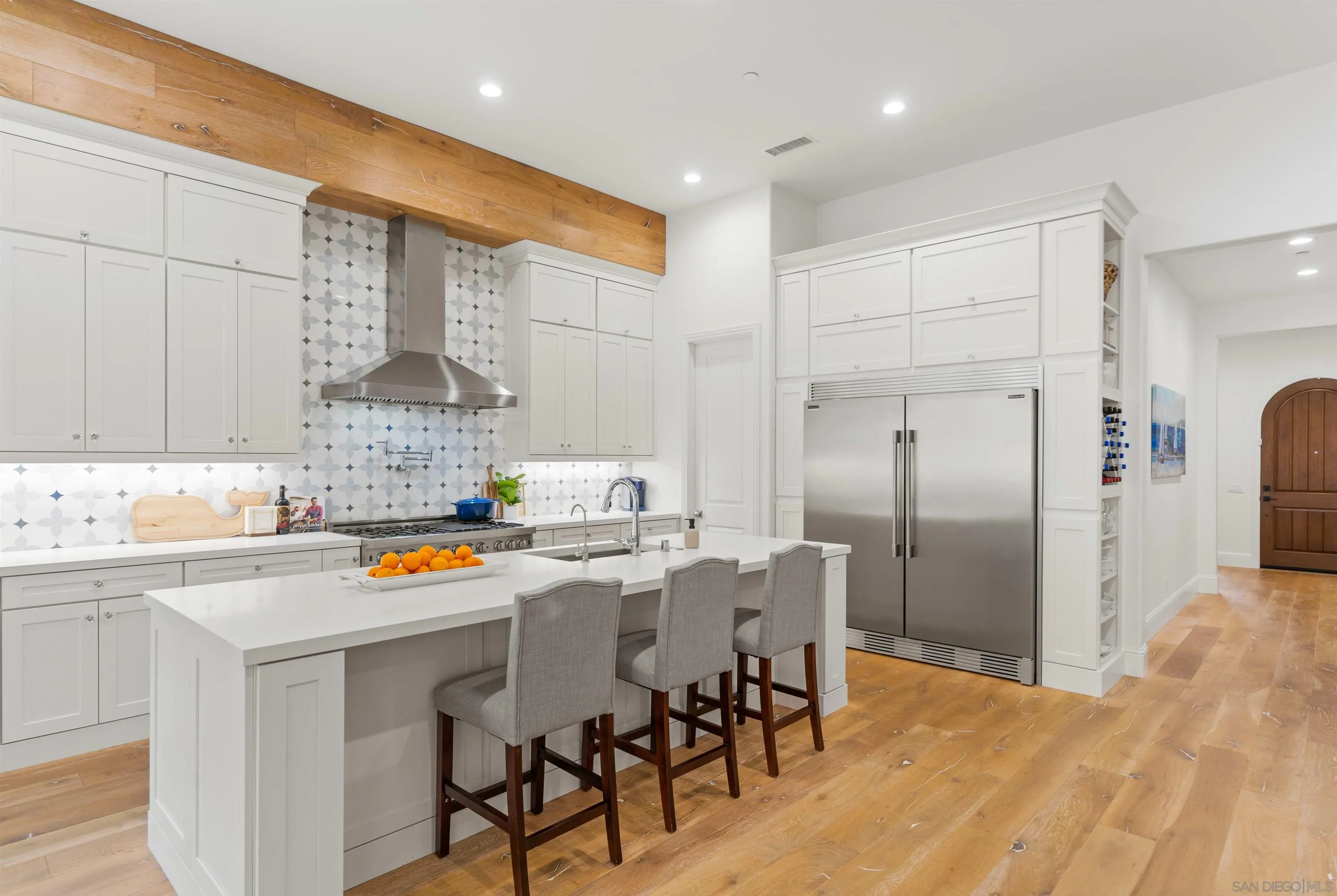 a kitchen with stainless steel appliances a sink a stove a refrigerator cabinets and dining table